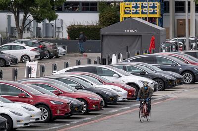 A cyclist rides past vehicles parked at the Tesla Inc. assembly plant in Fremont, California, U.S., on Monday, May 11, 2020. Elon Musk restarted production at Tesla’s only U.S. car plant, flouting county officials who ordered the company to stay closed and openly acknowledging he was risking arrest for himself and his employees. Photographer: David Paul Morris/Bloomberg