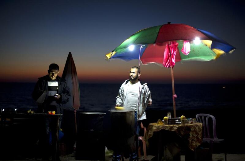 A man sells corn on the cob at his stall along the sea front in Gaza City, Palestine.  Mohammed Abed / AFP