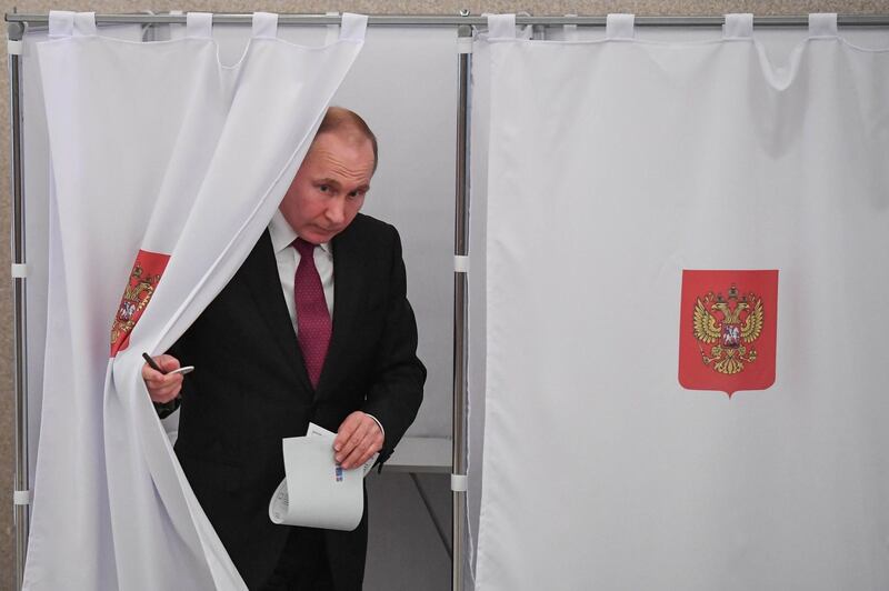 Presidential candidate, President Vladimir Putin walks out of a voting booth at a polling station during Russia's presidential election in Moscow on March 18, 2018. (Photo by Yuri KADOBNOV / POOL / AFP)