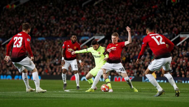 Scott McTominay tussles with Barcelona forward Lionel Messi. Reuters