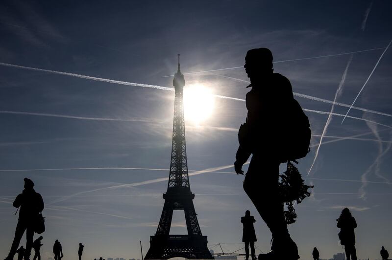 A street vendor walks along Trocadero Square waiting for tourists in Paris.  AFP