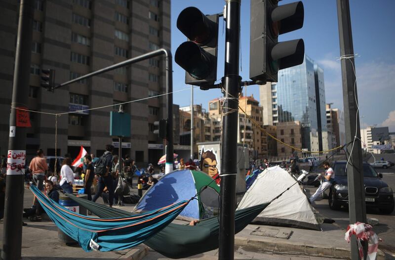 Lebanese anti-government protesters sleep in hammocks as they block a main avenue in the heart of Beirut during continuing protests in Lebanon's capital. AFP