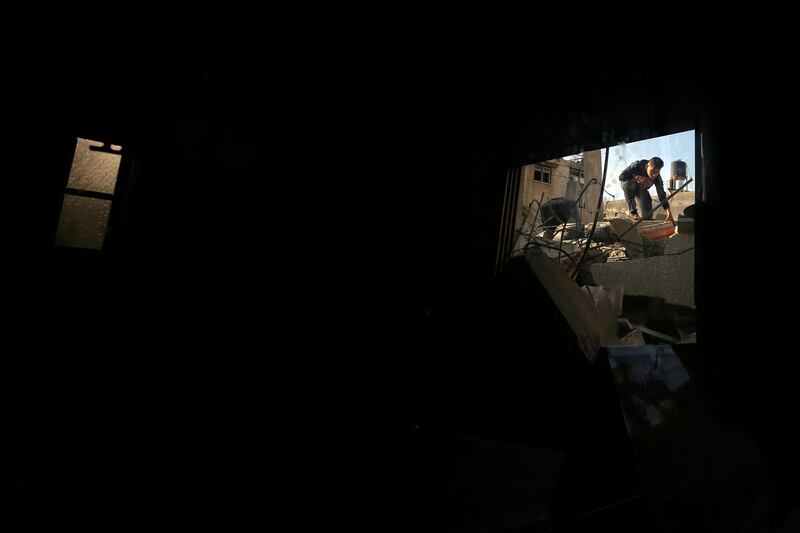 A Palestinian youth is seen through a window as he inspects a house destroyed by an Israeli air strike, in the southern Gaza Strip. Reuters