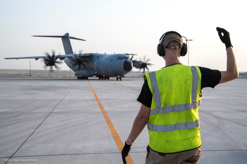 A ground controller guides a French Air Force Airbus A400M to its stand in Abu Dhabi, on a stopover en route to Afghanistan to help French citizens leave the country. AFP