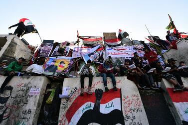 Iraqi protesters stand on concrete blocks placed by security forces to block the Jumhuriya bridge near Tahrir Square in central Baghdad. EPA