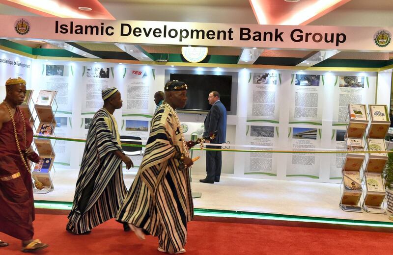 Traditional chiefs walk past an Islamic development Bank Group stand during the opening of the 44th meeting of the Ministers of Foreign Affairs of the Organisation of Islamic Cooperation (OIC) in Abidjan on July 10, 2017. / AFP PHOTO / ISSOUF SANOGO