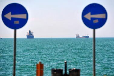 Cargo ships sail on the Mediterranean Sea seen beyond road traffic signs in Thessaloniki, Greece.Bloomberg