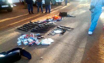 In this photo made available by the South African Police Services (SAPS), confiscated arms and ammunition, lay on the ground at a church in Zuurbekom, near Johannesburg, Saturday, July 11, 2020. Police in South Africa say five people are dead and more than 40 have been arrested after an early-morning hostage situation at a church near Johannesburg. (South African Police Services via AP)
