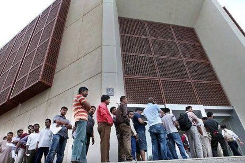 A long line of people waiting to pick up their Emirates ID cards wraps around the main post office in Abu Dhabi.