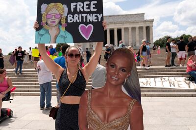 Maggie Howell, a supporter of pop star Britney Spears, protests next to a cardboard cutout of the singer at the Lincoln Memorial, during the Free Britney rally, in Washington, DC in July 2021. AP Photo