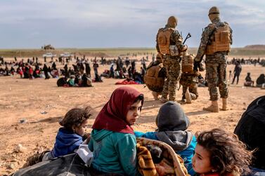 The US-backed Syrian Democratic Forces watch over women and children who fled ISIS-held territory near Baghouz, Syria, on March 5, 2019. AFP