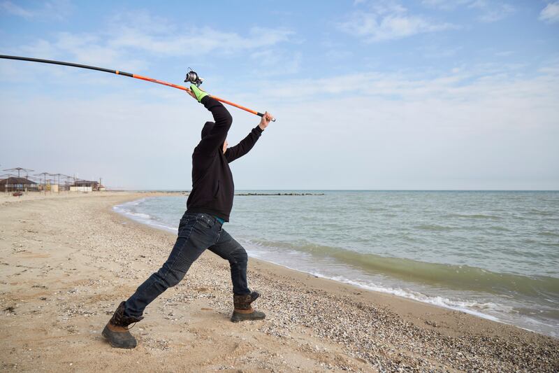 A fisherman tests his new fishing rod on a beach in Prymorsk, Ukraine. Getty Images
