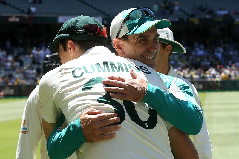 Australia's captain Pat Cummins gives a hug to team coach Justin Langer. AFP