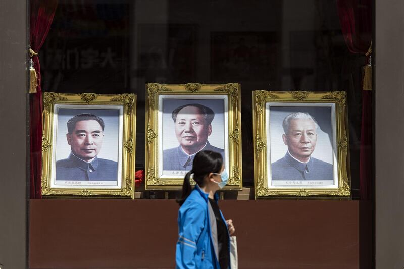 A pedestrian passes portraits of former Chinese leaders Zhou Enlai, left, Mao Zedong, centre, and Liu Shaoqi in Beijing, China. Bloomberg