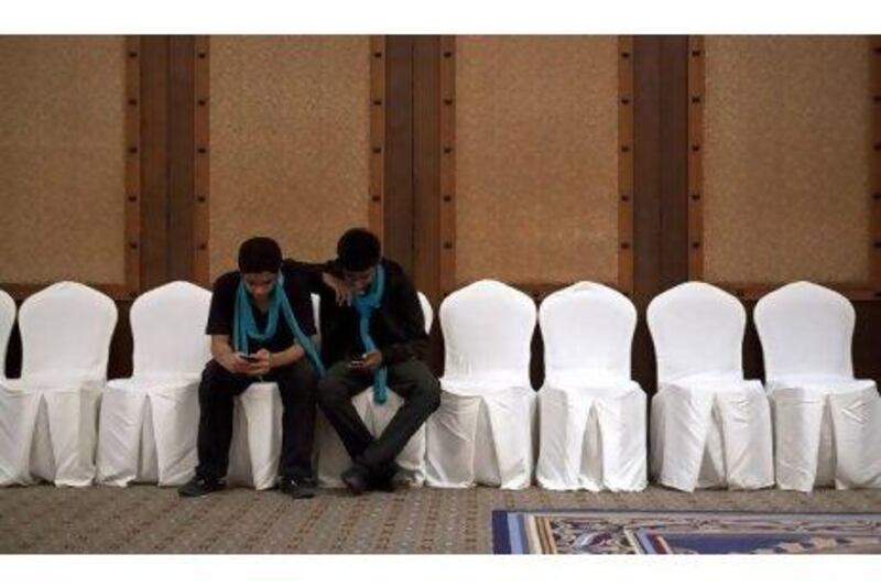 Volunteers take a break in between their duties at the Dubai International Film Festival yesterday. Jeff Topping / The National