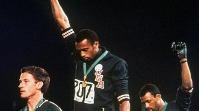 In this October 16, 1968 photo, US athletes Tommie Smith, centre, and John Carlos, right, stare downward during the playing of the "Star-Spangled Banner" after Smith received the gold and Carlos the bronze in the 200 metre run at the Summer Olympic Games in Mexico City. On the left is Peter Norman. AP Photo