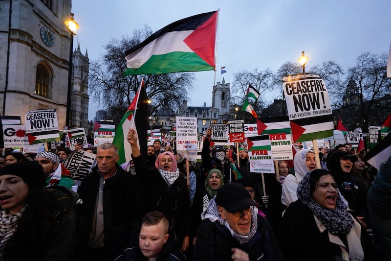 People take part in a Palestine Solidarity Campaign rally outside the Houses of Parliament, London. PA