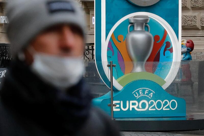 A person wearing a protective face mask walks past the Euro 2020 countdown clock, as the number of coronavirus (COVID-19) cases worldwide continues to grow, in central Saint Petersburg, Russia March 16, 2020. REUTERS/Anton Vaganov