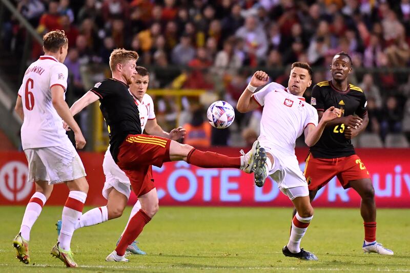 Kevin De Bruyne, left, and Poland's Jan Bednarek fight for the ball. AP