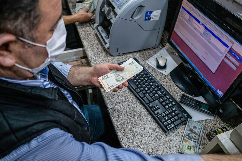A worker counts out Turkish lira banknotes for a customer at a currency exchange bureau in Istanbul, Turkey. Bloomberg