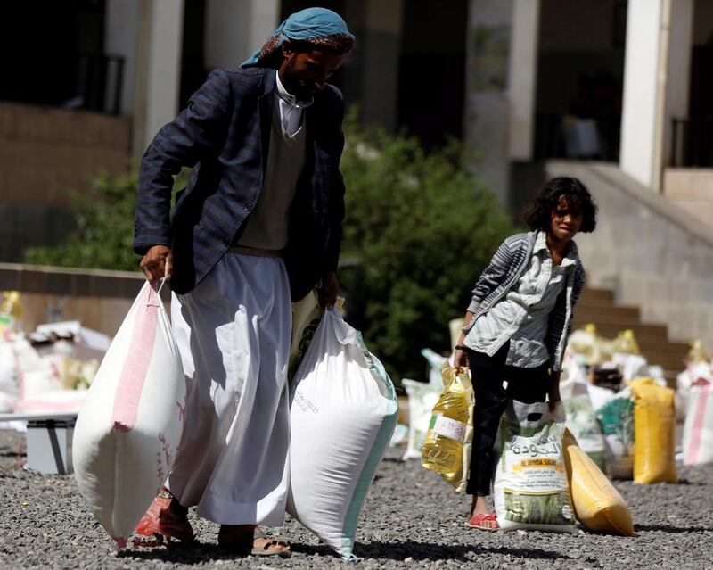A man carries sacks of wheat flour he received from a local charity during Ramadan in Sanaa on May 29, 2017. Khaled Abdullah / Reuters