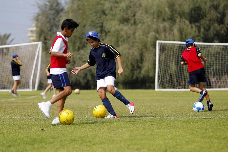 A year six PE class where the students learn football skills outdoors at Jebel Ali Primary in Dubai. Sarah Dea / The National 