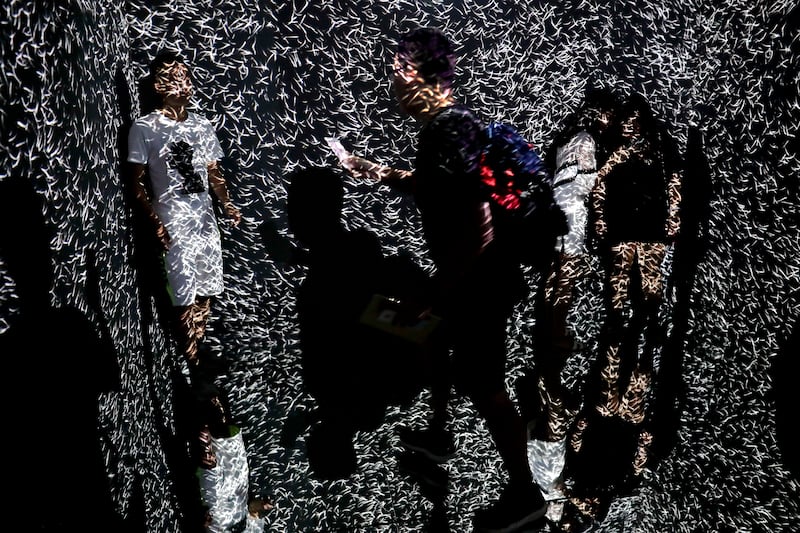 Visitors are beamed by light pattern at an art installation titled Infinity Room displayed during The Future of Today Exhibition. Andy Wong / AP photo