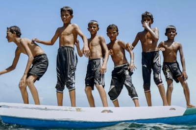 Moments from the film including the opening sequence showing Ahmed and his friends playing at sea. Real Film; Filmoption International. Courtesy Fine Point Films