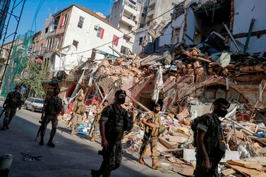Lebanese soldiers walk past a partially destroyed traditional building which was affected by the Beirut port blast, in the Gemmayzeh neighbourhood, on August 26, 2020 AFP