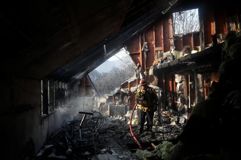 Captain Adrian Murrieta looks for hot spots on a wildfire-ravaged home in Malibu. AP Photo