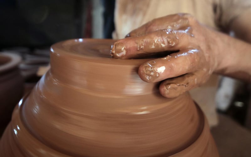 An Egyptian potter shapes a clay ornament at a pottery workshop, in Old Cairo.
