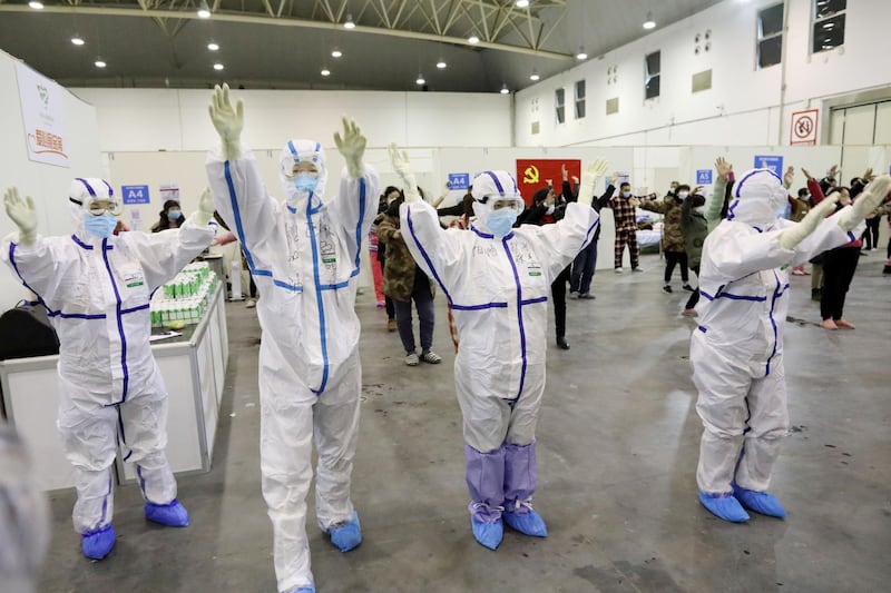 Medical workers in protective suits dance with patients inside the Wuhan Parlor Convention Centre that has been converted into a makeshift hospital following an outbreak of the novel coronavirus, in Wuhan, Hubei province, China. China Daily via Reuters