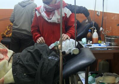 A picture shows people being treated at a field hospital after an alleged poison gas attack by troops loyal to President Bashar al-Assad in the rebel-held city of Daraya, southwest of the capital Damascus, on January 13, 2014.  At least three people were killed in the attack, Syria's main opposition National Coalition alleged in a statement. It also said the army's attack was linked to a bid by the Assad regime to ensure the opposition rejects participation in peace talks next week in Switzerland. AFP PHOTO/FADI DIRANI (Photo by FADI DIRANI / AFP)