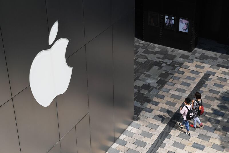 People walk past an Apple store in Beijing on August 3, 2017. 
Apple has removed software allowing internet users to skirt China's "Great Firewall" from its app store in the country, the company confirmed, sparking criticism that it was bowing to Beijing's tightening web censorship. / AFP PHOTO / GREG BAKER