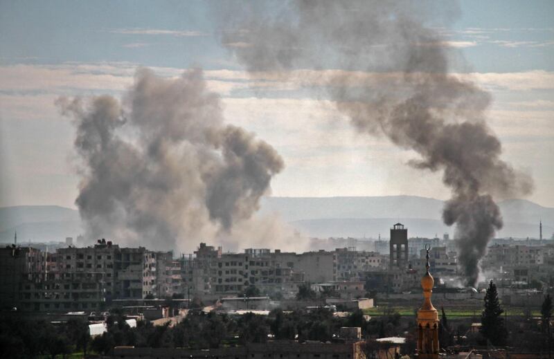 Smoke rises from buildings following a bombardment on the village of Mesraba in the rebel-held besieged Eastern Ghouta region on the outskirts of the capital Damascus, on February 19, 2018. Hamza Al-Ajweh / AFP
