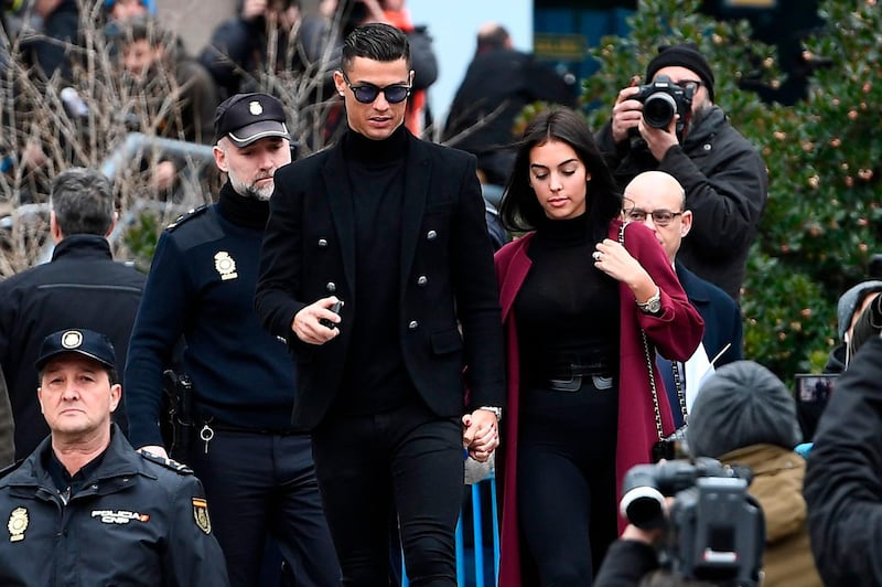 Juventus' forward and former Real Madrid player Cristiano Ronaldo leaves with his Spanish girlfriend Georgina Rodriguez after attending a court hearing for tax evasion in Madrid on January 22, 2019. Ronaldo is expected to be given a hefty fine after Spanish tax authorities and the player's advisors made a deal to settle claims he hid income generated from image rights when he played for Real Madrid. / AFP / PIERRE-PHILIPPE MARCOU
