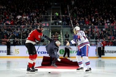 Jose Mourinho, centre, falls as he drops the puck to start a Continental hockey league match in Balashikha on Monday. AFP