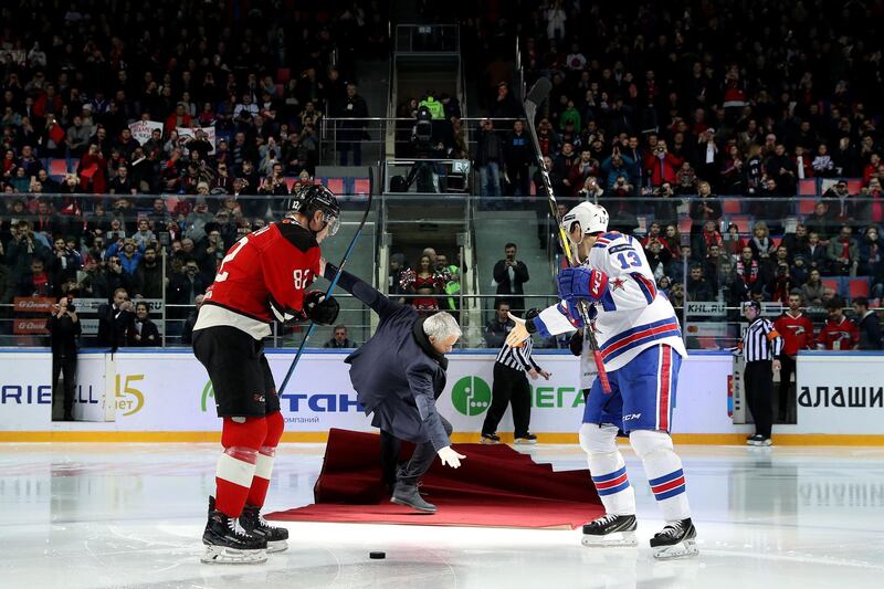 TOPSHOT - Manchester United's Portuguese manager Jose Mourinho (C) falls as he drops the puck to start a Continental hockey league match between Avangard Omsk and SKA Saint Petersburg in Balashikha outside Moscow on February 4, 2019. / AFP / STRINGER
