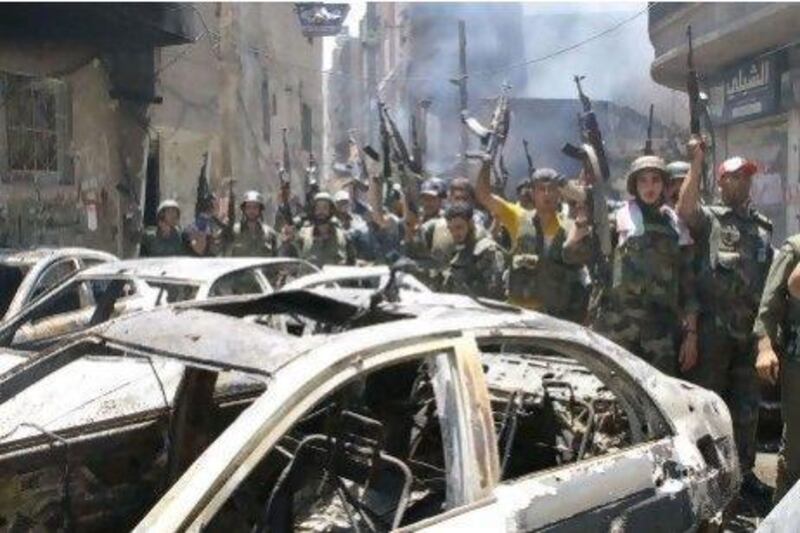 Syrian soldeirs celebrate in the Al Midan area in Damascus after claiming to have "cleaned" the district of "terrorists". But rebels said that they had made a tactical withdrawal.