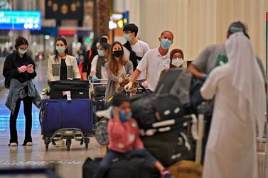 Passengers from an Emirates flight from London queue up to get screened by health workers at Dubai International Airport on Friday. AFP