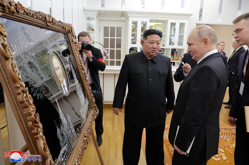 Mr Putin is presented with a gift by Mr Kim during his state visit. Reuters