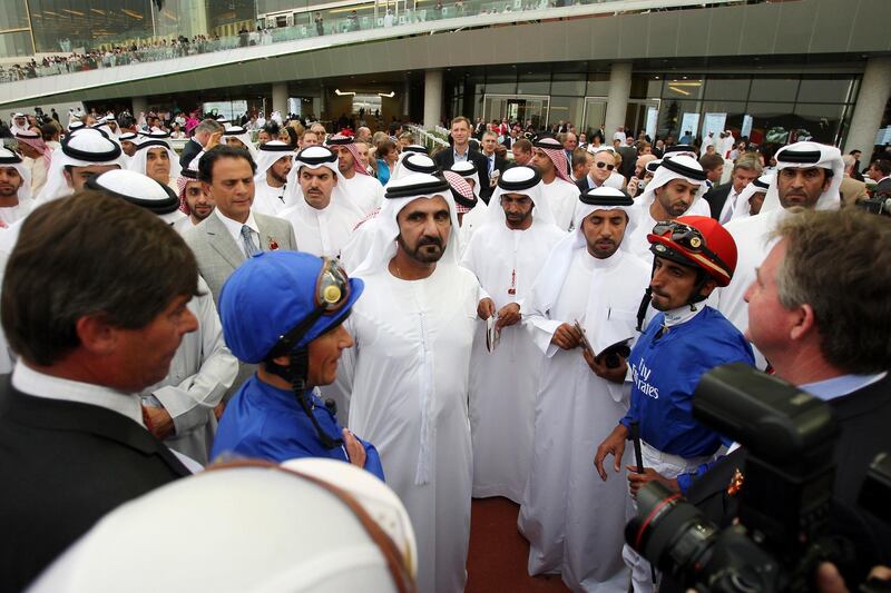 27/03/10 - Dubai, UAE - Sheikh Mohammed bin Rashid al Maktoum, Vice President of UAE and Ruler of Dubai, stands with winning jockey Ahmad Ajtebi riding Calming Influence (IRE), #4, in the Godolphin Mile at Meydan Racecourse.   ( Pawan Singh / The National )