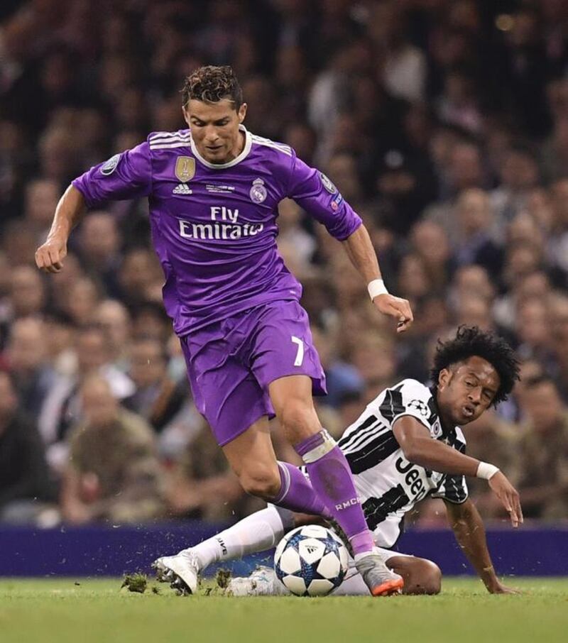 Juventus’ Colombian midfielder Juan Cuadrado, right, tackles Real Madrid’s Portuguese striker Cristiano Ronaldo. Javier Soriano / AFP