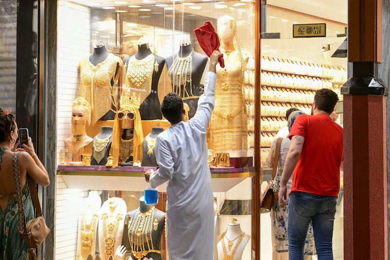 A shopkeeper makes sure that his windows gleam as much as the gold items on sale behind them.