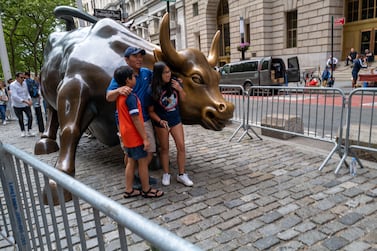 NEW YORK, NEW YORK - JUNE 14: People pose with the Wall Street Bull in the financial district in Manhattan on June 14, 2022 in New York City.  The Dow was up in morning trading following a drop on Monday of over 800 points, which sent the market into bear territory as fears of a possible recession loom.  (Photo By Spencer Platt / Getty Images)
