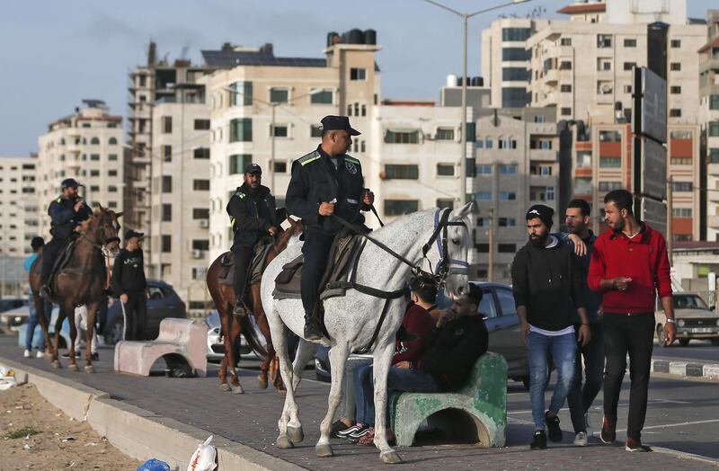 Palestinian mounted policemen instruct people at the Gaza beachfront to return home as part of measures to stem the spread of the Covid-19 pandemic.  AFP