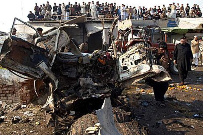 Pakistani security officials inspect the wreckage of a vehicle which exploded in Jamrud, killing 35.