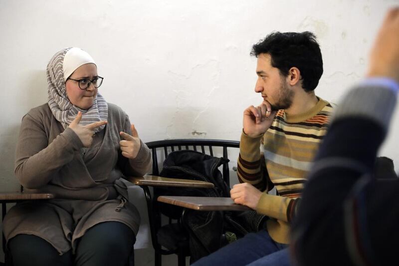 Syrian bio-medical engineer and sign language teacher Wisal Al Ahdab communicates using sign language with 21-year-old deaf student Riyad Hommos during a class at the EEMAA association, an NGO centre for the deaf in Damascus’ Midan district on March 7, 2016. Joseph Eid/AFP