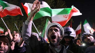 Demonstrators wave Iran's flag and Palestinian flags as they gather in front of the British Embassy in Tehran on Sunday. AFP