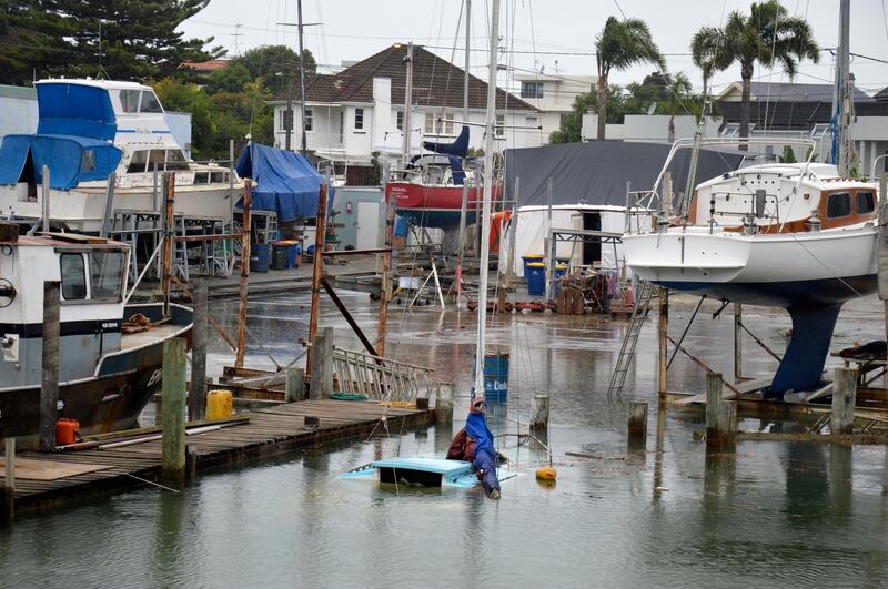 A photo provided by Ben Sheeran shows boats swamped by flooding from a king tide in Milford Marina, Auckland, New Zealand. King Tides Auckland via AP